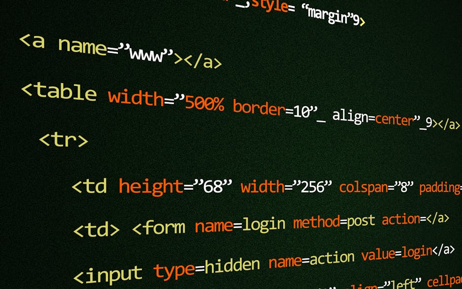 A close-up image shows a person's hand typing on a silver laptop with a black keyboard, placed on a wooden surface. The laptop screen displays lines of colorful code, indicating a programming or websi